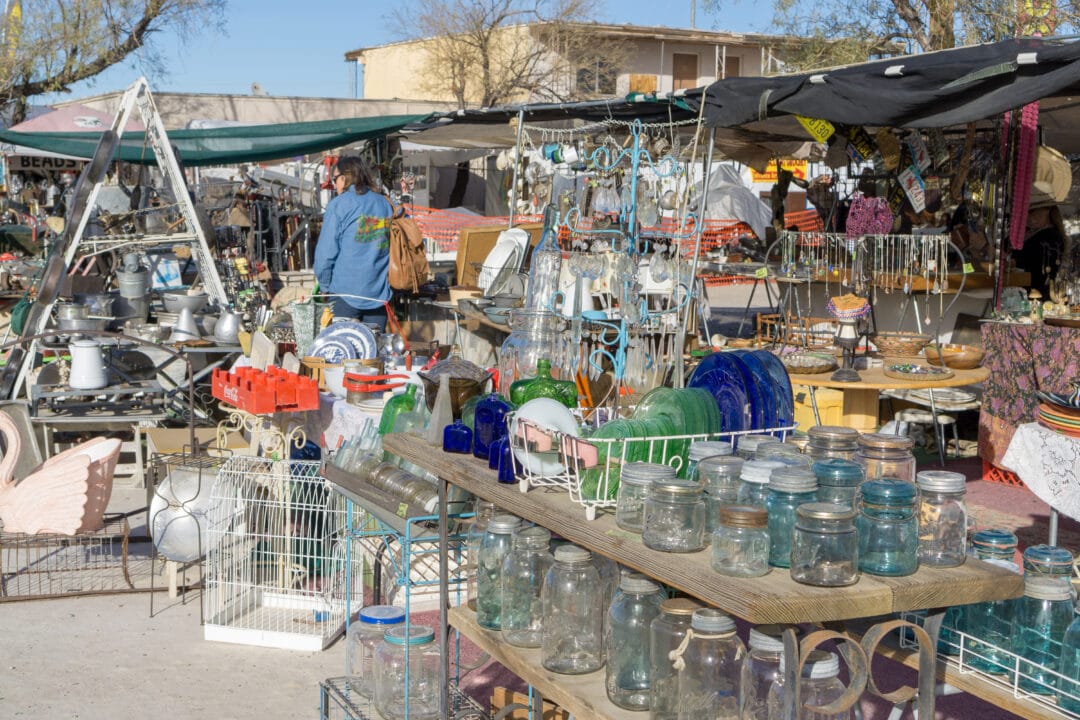 Vendors display a variety of items at an outdoor market.
